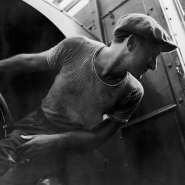 Man leaning out of truck, dockworkers, NYC, 1947